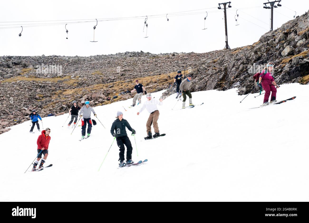 Skieurs et snowboardeurs sur les restes de neige sur Meall a'Bhuiridh à Glencoe comme ils prennent part au ski de milieu d'été. L'événement, organisé par le Glencoe Mountain Resort, se tient chaque année le week-end le plus proche du solstice d'été. Date de la photo: Dimanche 20 juin 2021. Banque D'Images