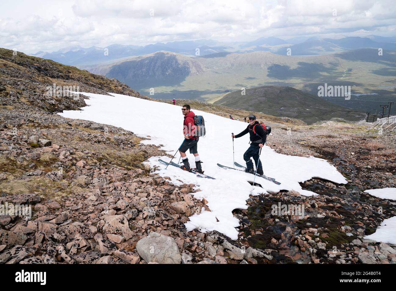 Skieurs sur les restes de neige sur Meall a'Bhuiridh à Glencoe comme ils prennent part au ski de milieu d'été. L'événement, organisé par le Glencoe Mountain Resort, se tient chaque année le week-end le plus proche du solstice d'été. Date de la photo: Dimanche 20 juin 2021. Banque D'Images