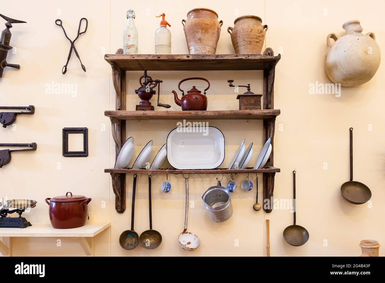 Vejer de la Frontera, Cadix, Espagne - 14 juin 2021 : anciens ustensiles de cuisine sur des étagères en bois et fixés au mur d'une maison andalouse typique en V Banque D'Images