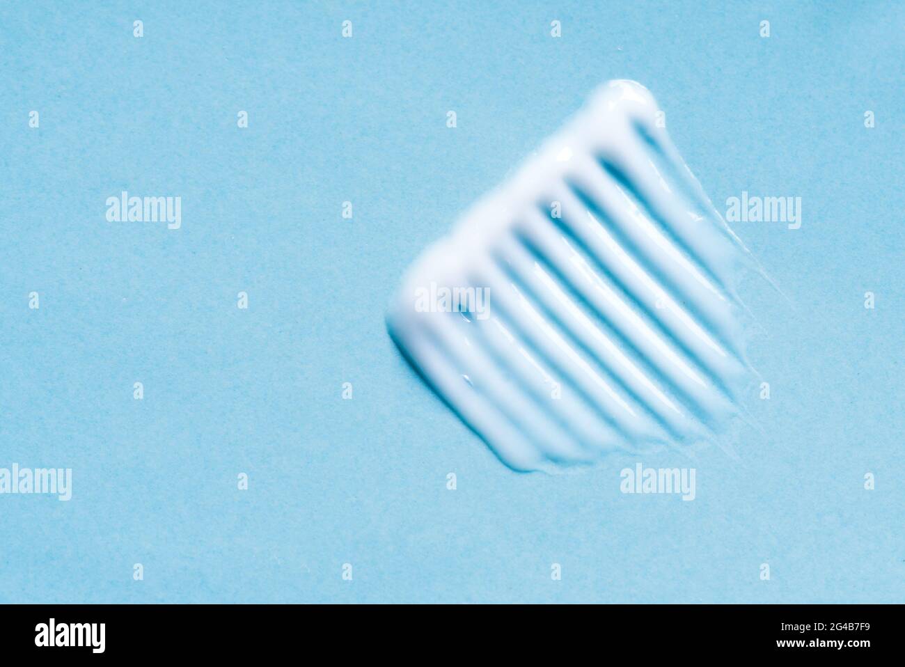 Nuance de baume pour le visage ou le corps sur fond bleu, gros plan. Trait de produit cosmétique. Banque D'Images