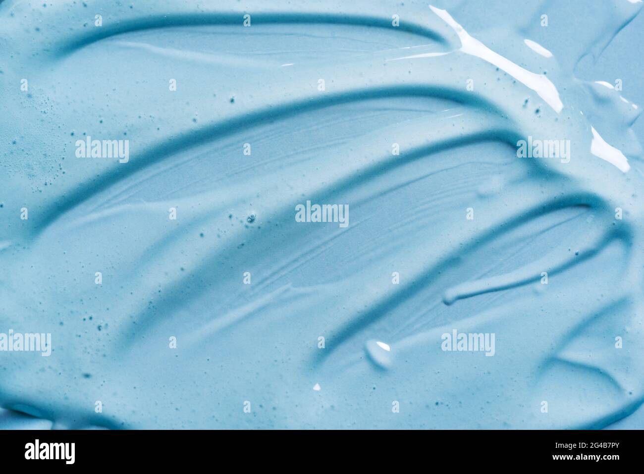 Texture gel sur fond bleu gros plan. Produits cosmétiques en gel transparent. Banque D'Images