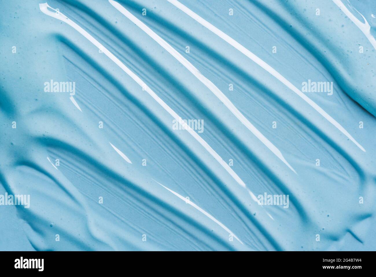 Texture gel sur fond bleu gros plan. Produits cosmétiques en gel transparent. Banque D'Images