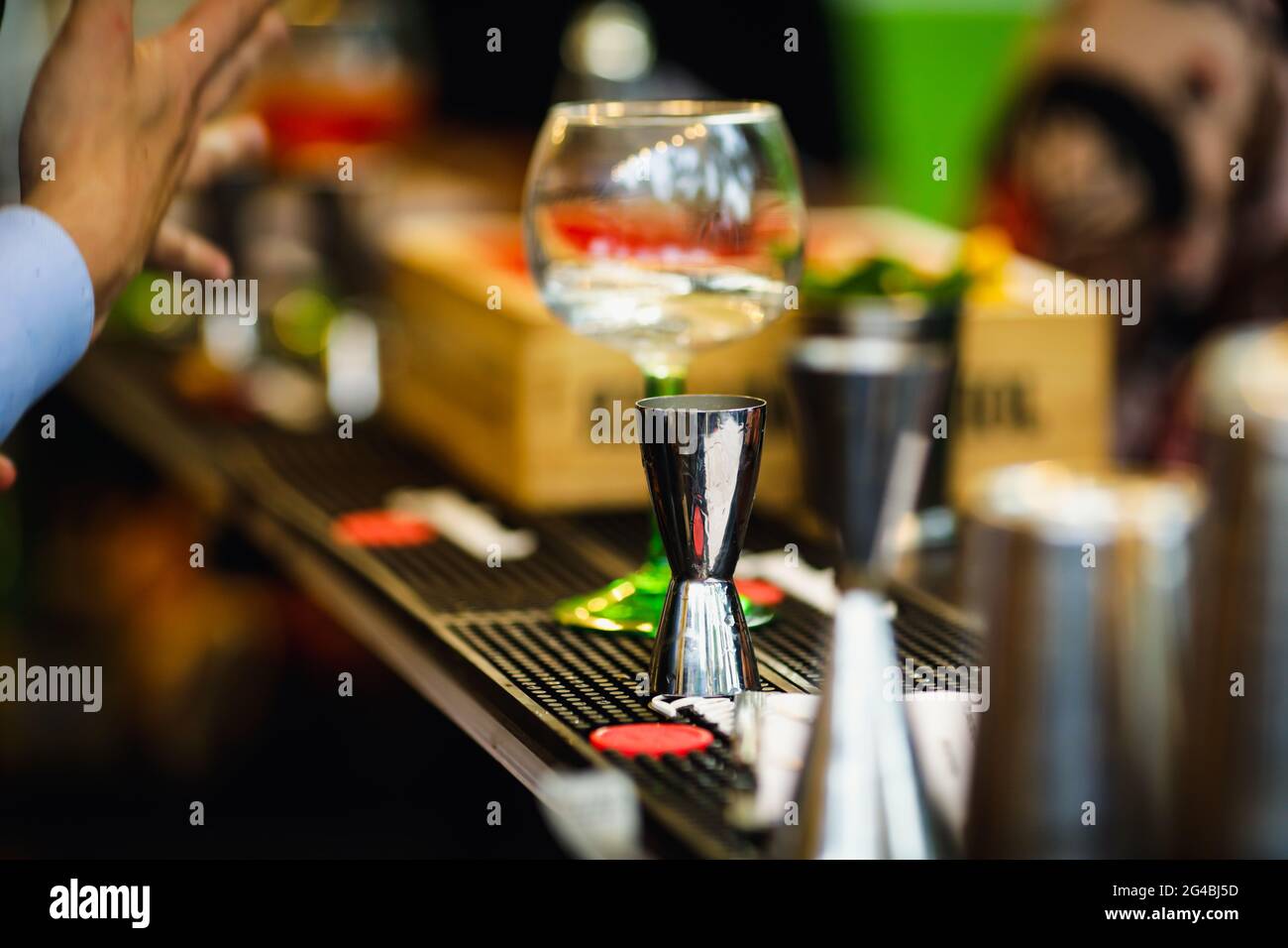 Image de faible profondeur de champ (mise au point sélective) avec des turluttes d'alcool d'un barman sur le comptoir d'une barre. Banque D'Images