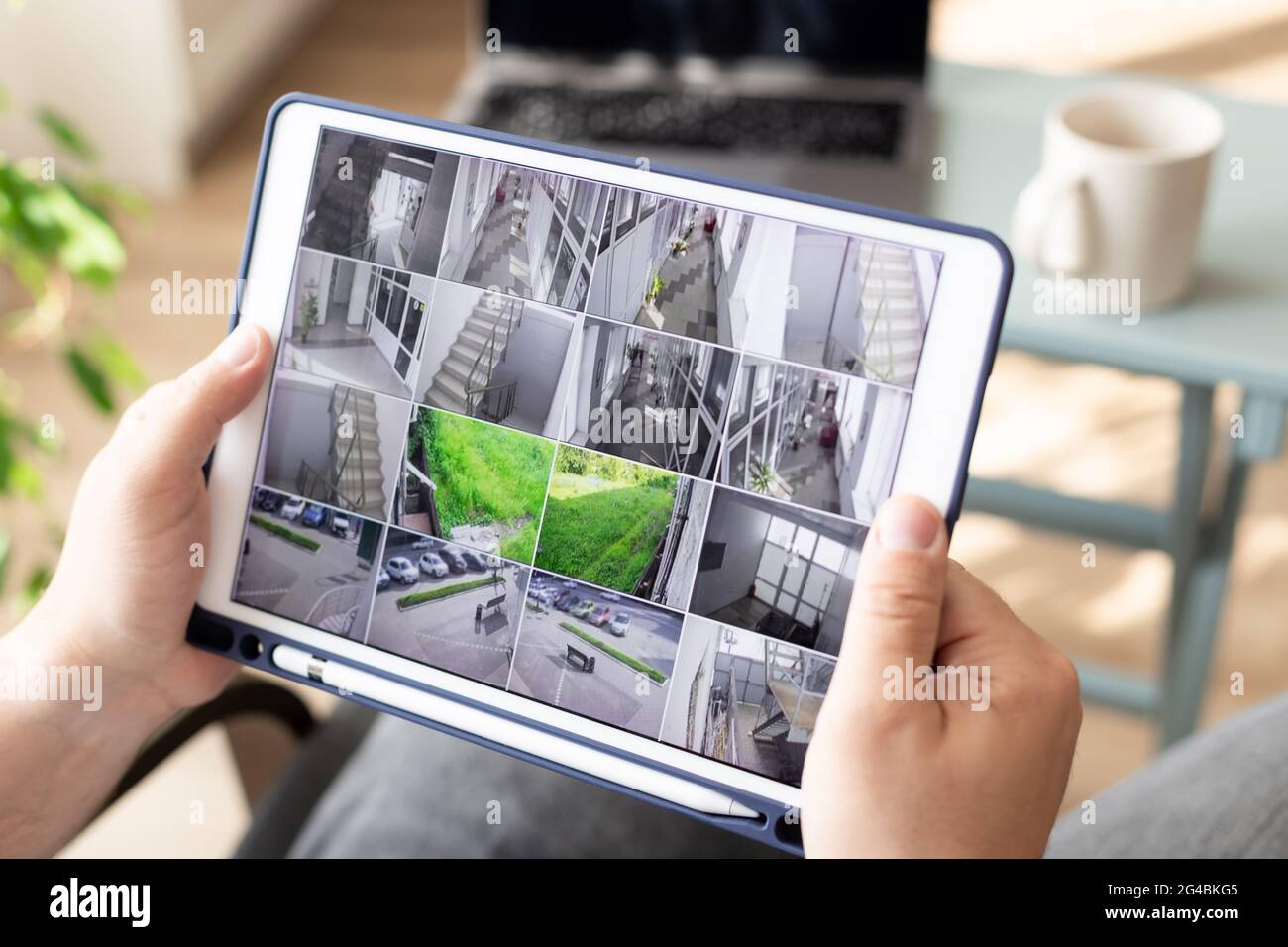 Homme surveillant des caméras cctv modernes sur une tablette numérique à l'intérieur Banque D'Images