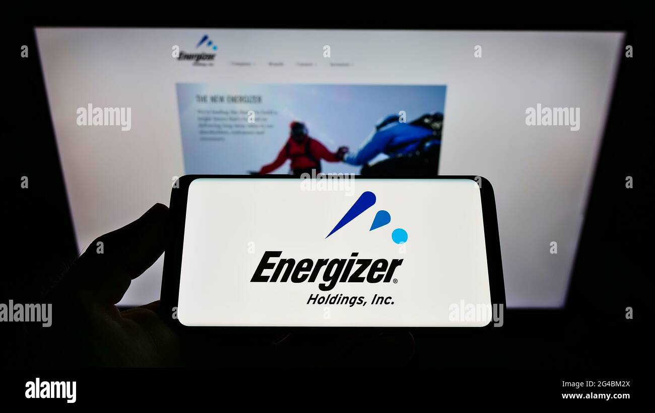 Personne tenant un téléphone portable avec le logo du fabricant de batterie américain Energizer Holdings Inc. À l'écran en face de la page Web. Mise au point sur l'affichage du téléphone. Banque D'Images