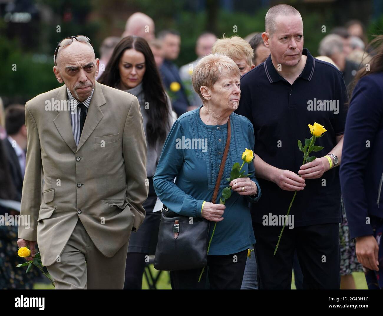 Les membres de la famille du Dr David Wails, y compris son frère Andrew (à droite), attendent de déposer une seule rose jaune sur le kiosque à Forbury Gardens à Reading, pendant un service commémoratif pour marquer l'anniversaire de l'attaque terroriste au cours de laquelle le Dr David Wails, 49 et ses deux amis, James Furlong, 36 ans, et Joseph Ritchie-Bennett, 39 ans, Ont été mortellement poignardé par le demandeur d'asile libyen kairi Saadallah, âgé de 26 ans, tout en profitant d'une soirée d'été ensemble alors que les restrictions de verrouillage se sont assouplies, le 20 juin de l'année dernière. Date de la photo: Dimanche 20 juin 2021. Banque D'Images