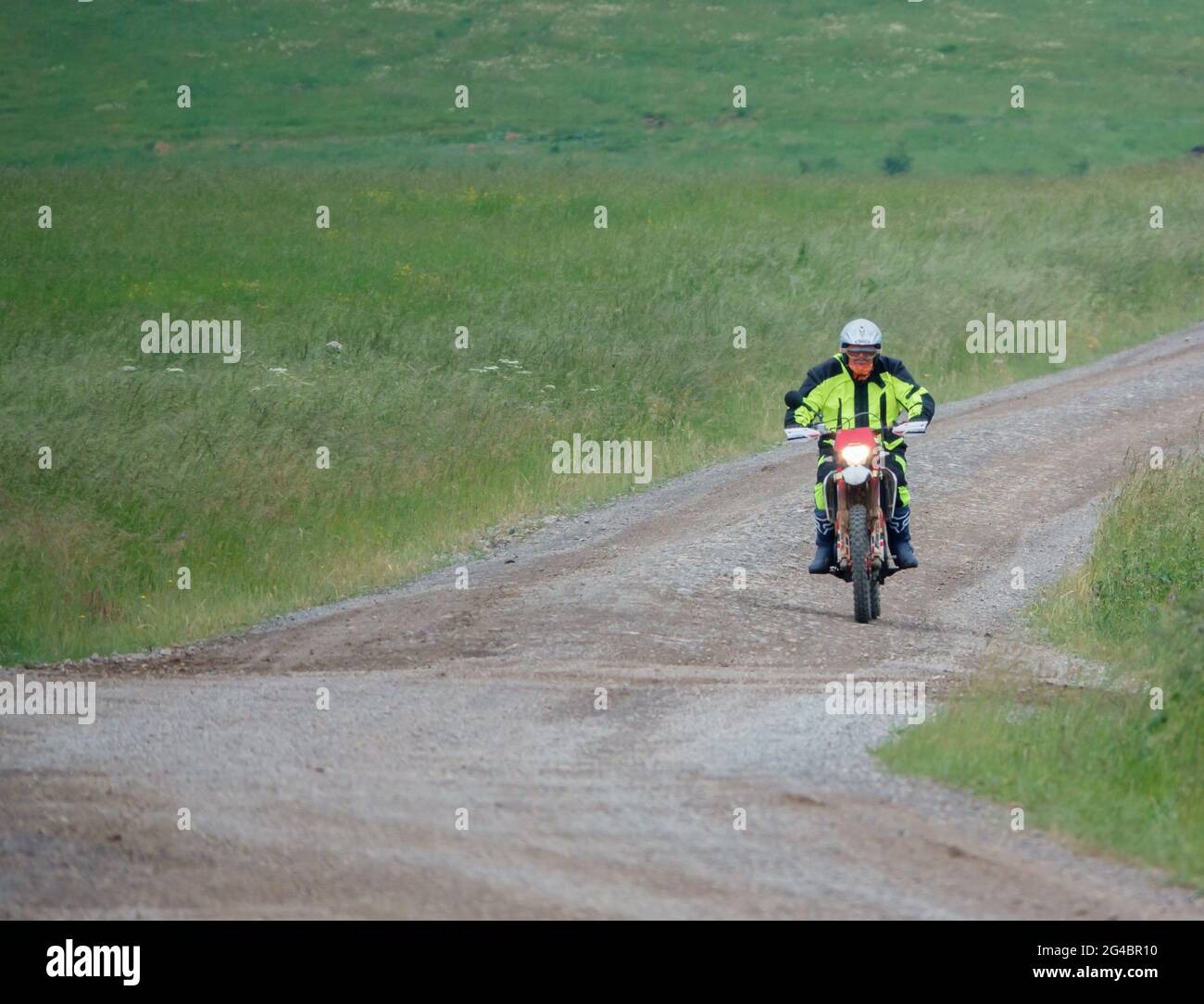 Un cycliste à moteur (motard) qui fait rouler sa moto le long d'une piste de pierre sur la plaine de Salisbury, dans le Wiltshire Banque D'Images