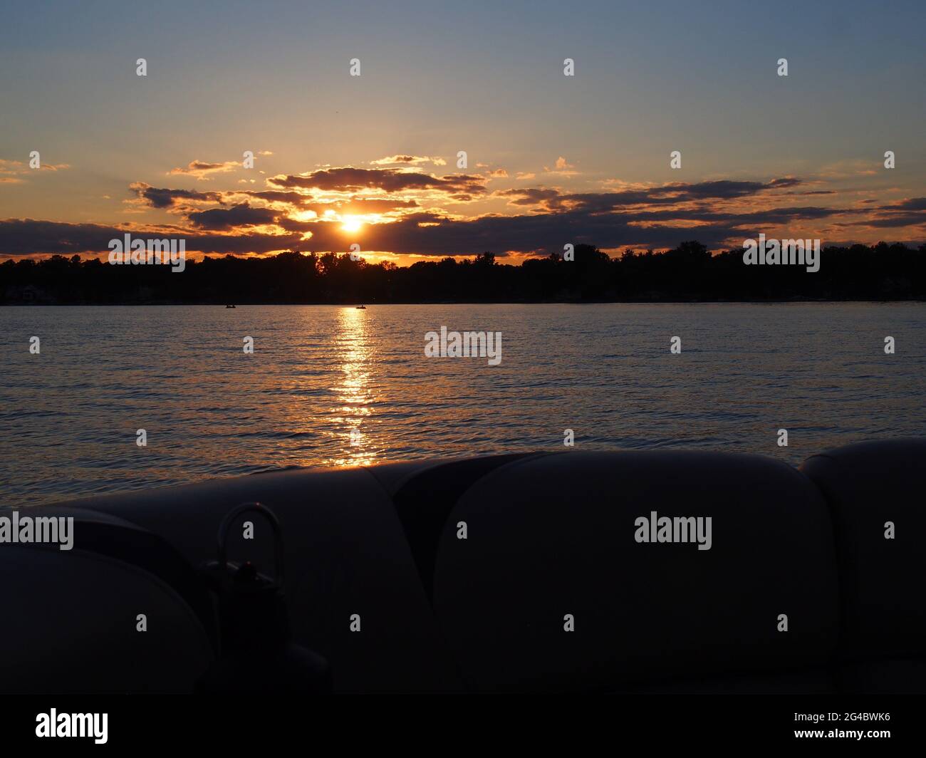 Coucher de soleil sur le lac se reflétant sur le ponton sur le lac Lansing à Haslett, mi. ÉTATS-UNIS Banque D'Images Coucher de soleil sur le lac se reflétant sur le ponton sur le lac Lansing à Haslett, mi. ÉTATS-UNIS Banque D'Images