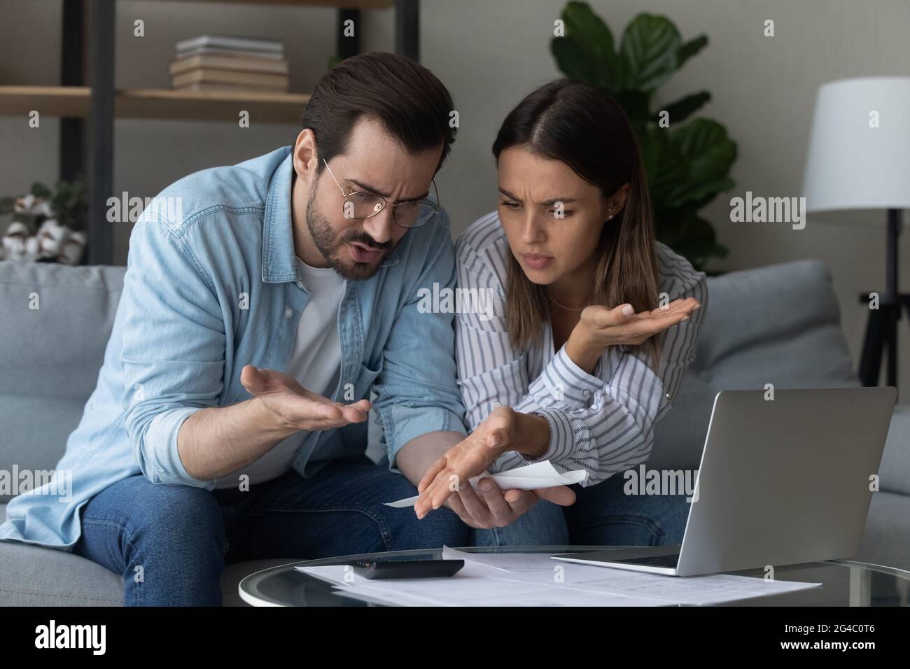 Couple de jeunes familles anxieux calculant les dépenses domestiques. Banque D'Images