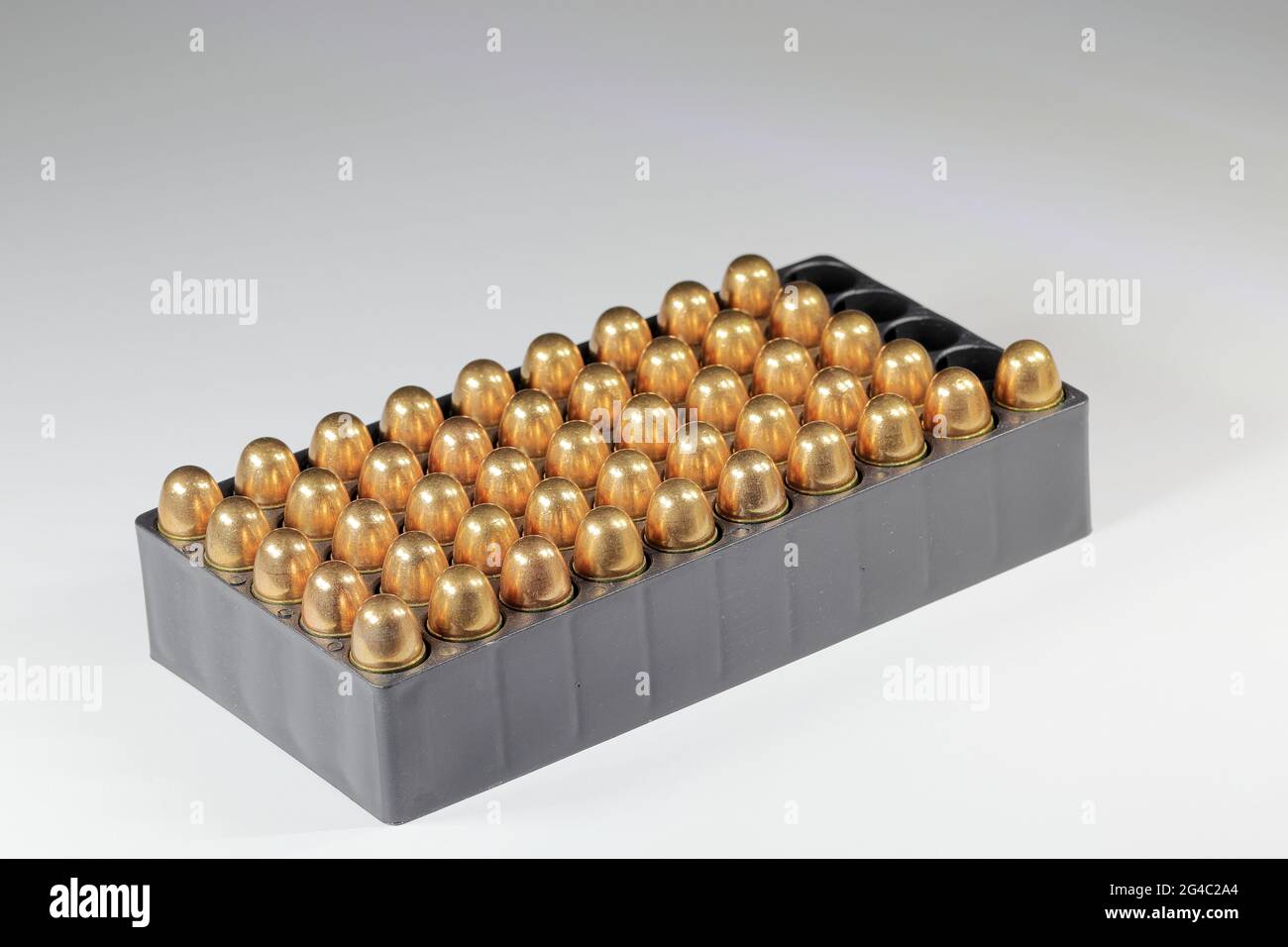 lot de balles 11 mm ou 0,45 acp FMJ (gaine entièrement métallique) prêt à l'emploi, isoler sur une surface de réflexion d'arrière-plan blanche. Banque D'Images