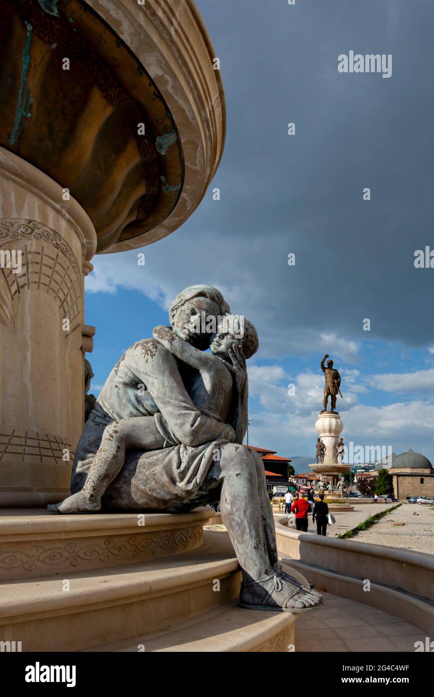 Bébé Alexandre le Grand dans les bras de sa mère Olympias avec la statue de son père le roi Phillip en arrière-plan, Skopje, Macédoine du Nord Banque D'Images