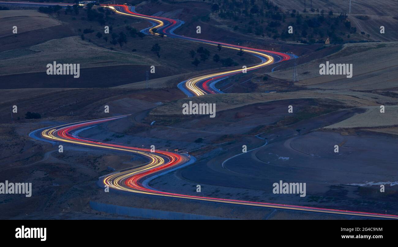 Traces des phares des voitures sur un col de montagne dans la soirée Banque D'Images