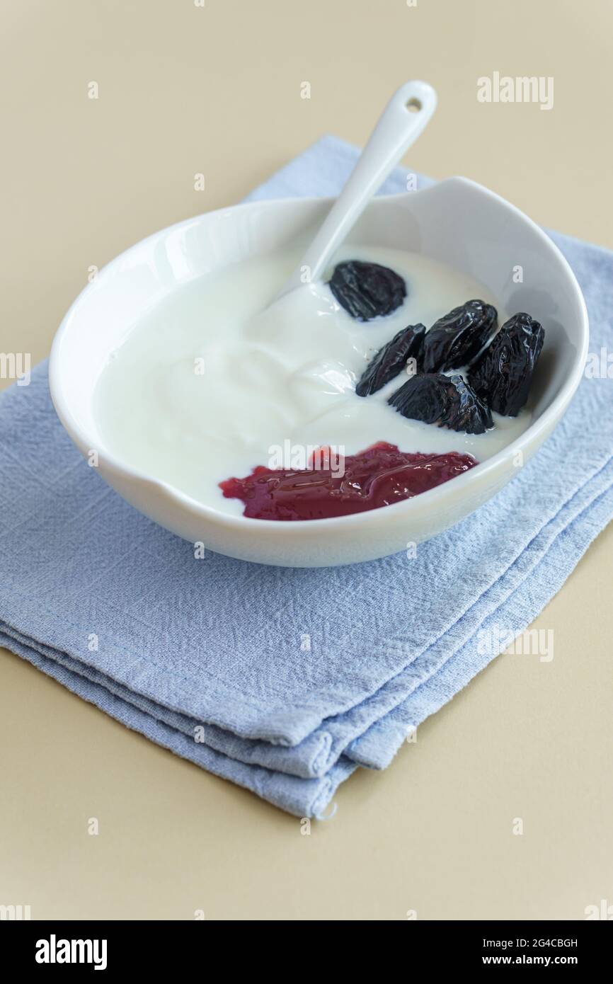 Yaourt avec pruneau séchée dénoyautée dans un bol. Régime de récupération de digestion concept Banque D'Images