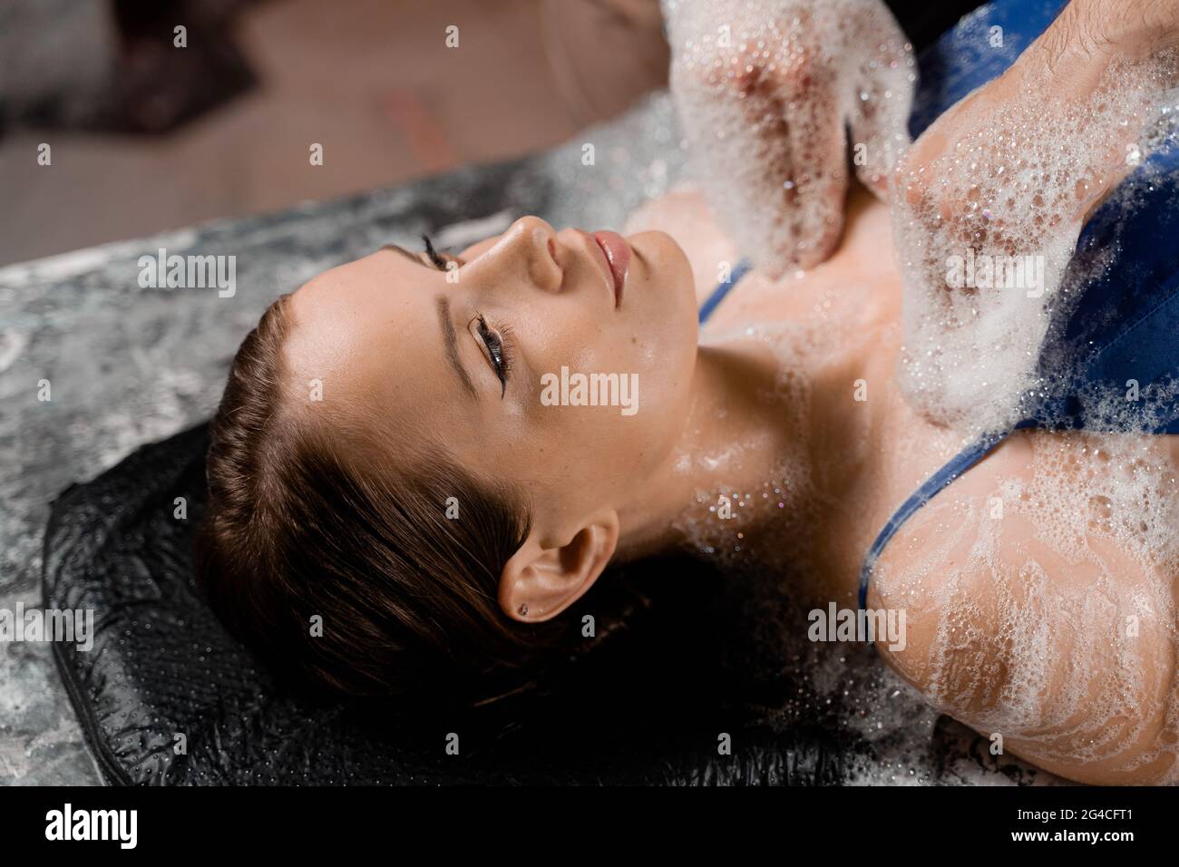 Massage en gros plan avec gommage à la mousse pour le modèle au spa. Détente au hammam turc. Banque D'Images