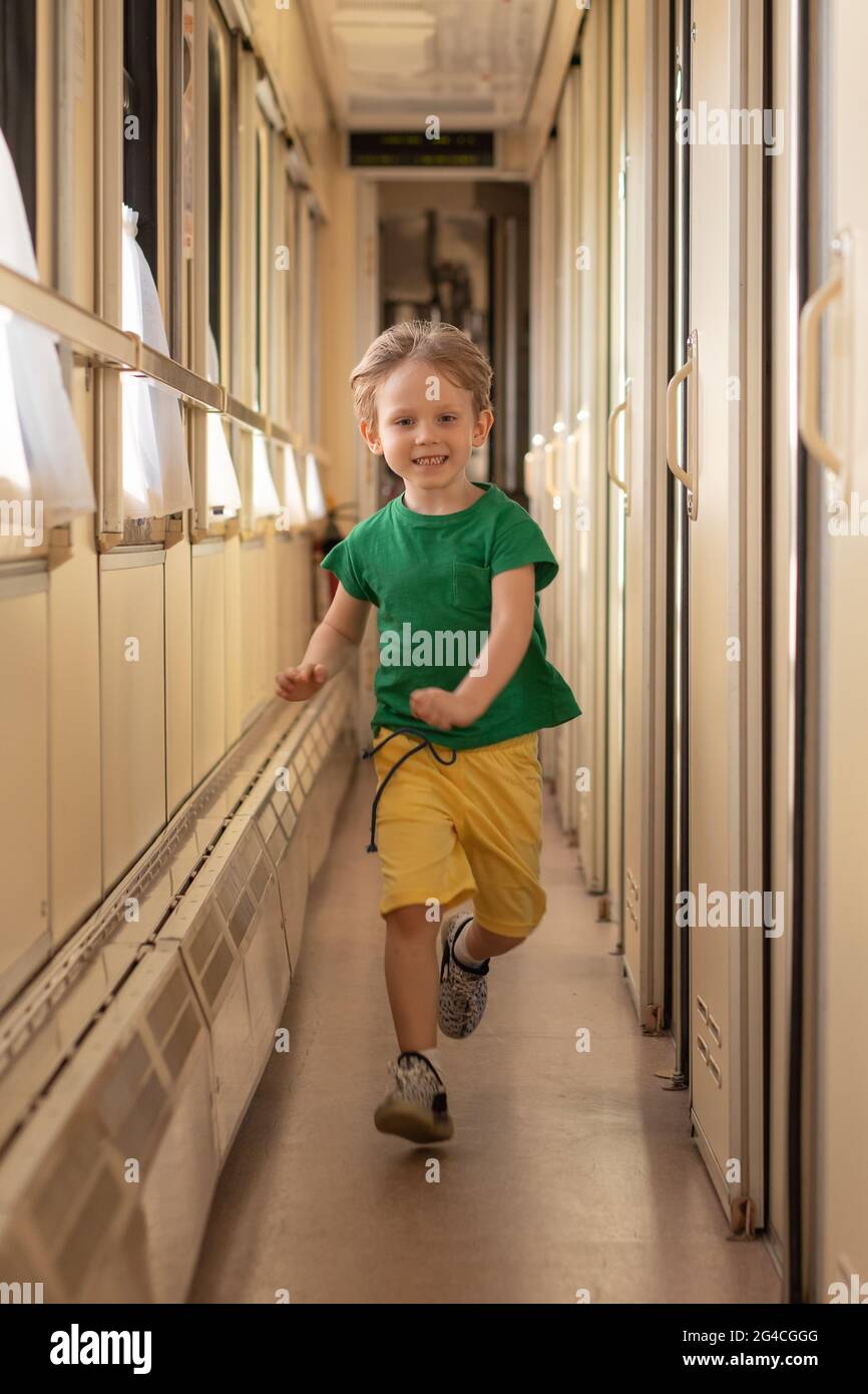Le petit garçon gamin de l'enfant en train se met en garde-tête. Voyage et enfants concept passager au chemin de fer. Prise de vue verticale, style de vie. Banque D'Images
