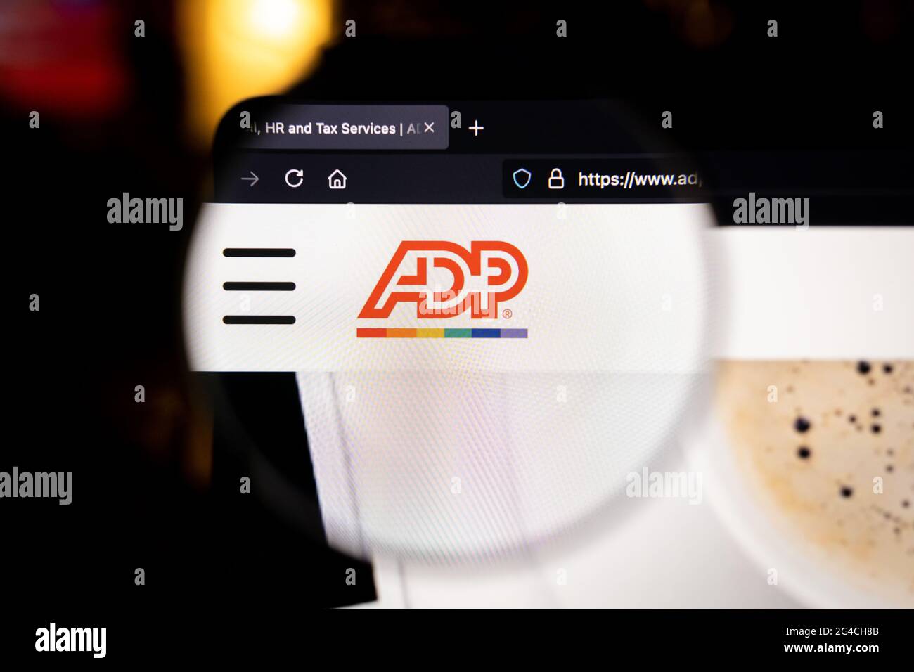 Logo de la société ADP sur un site Web, vu sur un écran d'ordinateur par une loupe. Banque D'Images