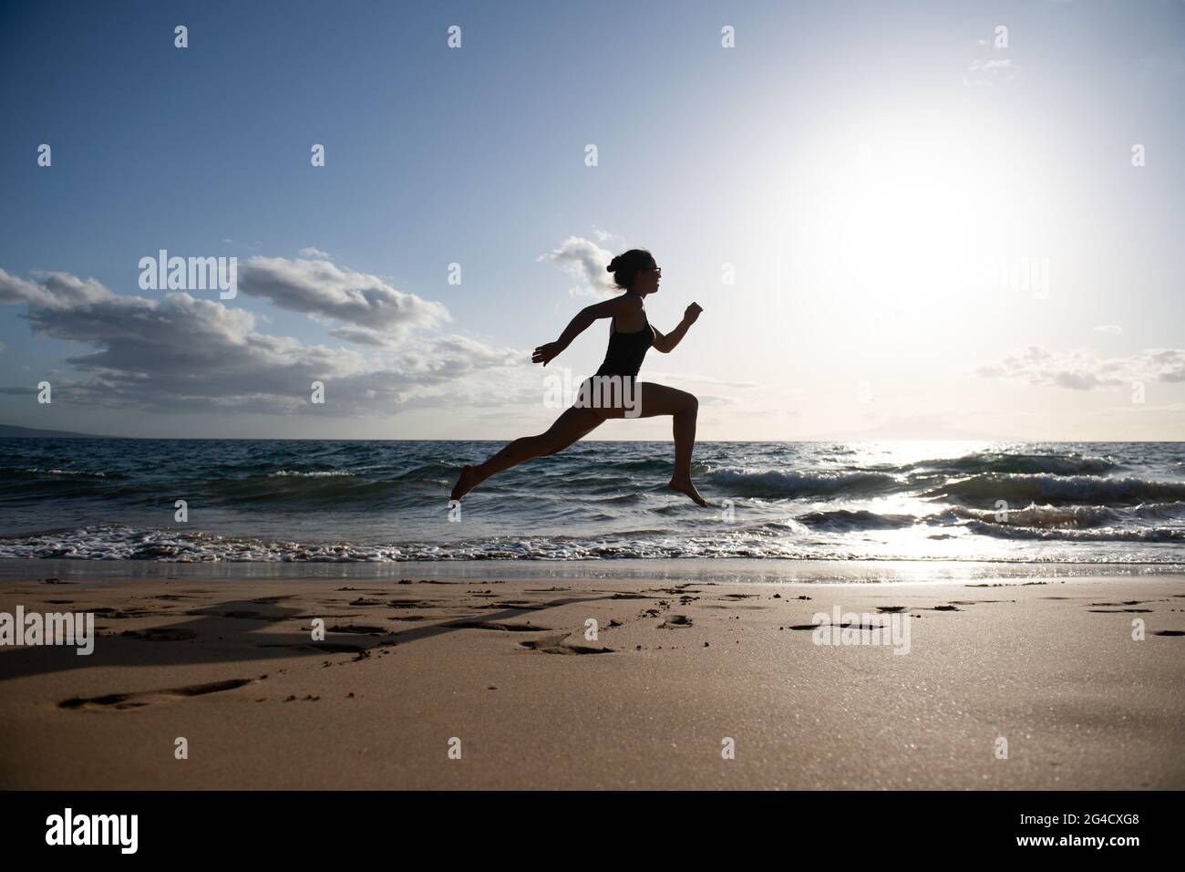 Femme en train de courir sur la plage. Belle jeune fille dans les vêtements  de sport courant sur la mer Photo Stock - Alamy