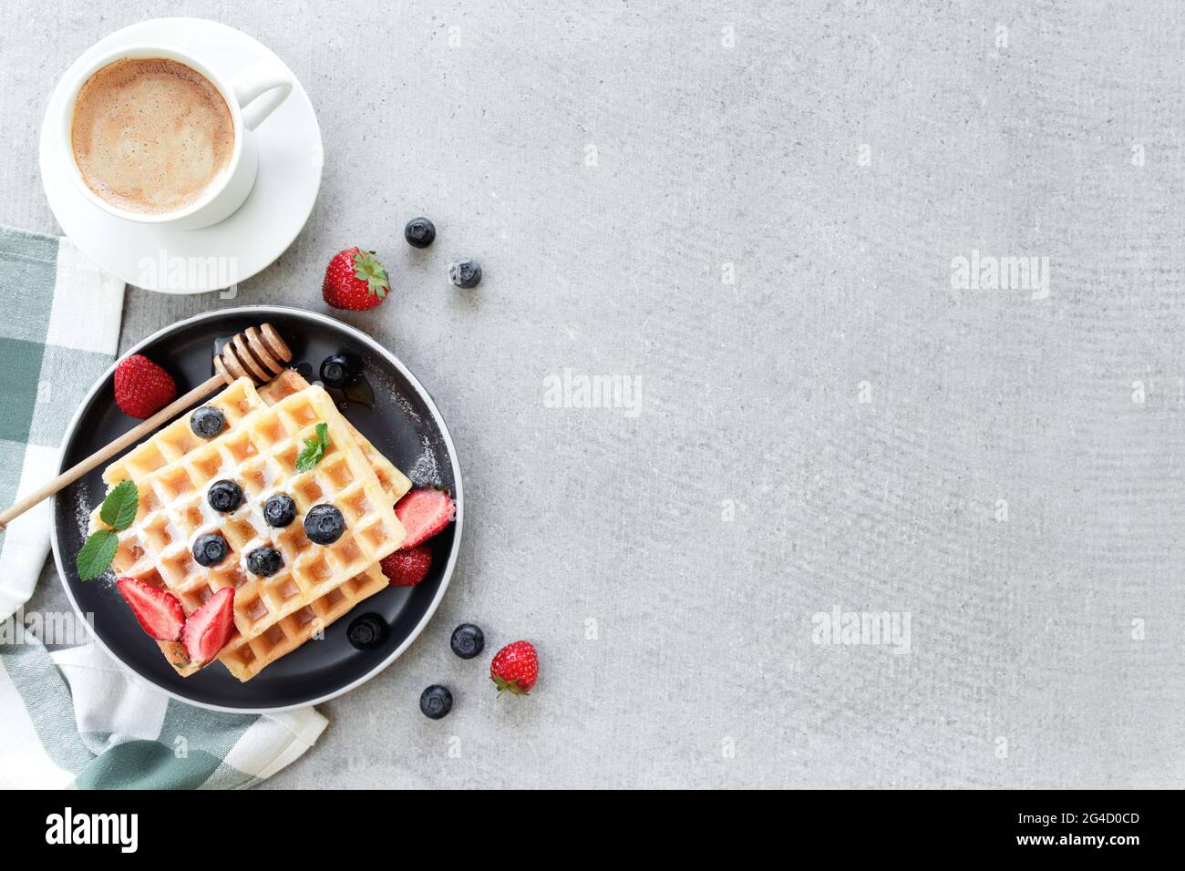 Assiette de gaufres sur la table avec myrtille, fraise, menthe et tasse de café blanc Banque D'Images