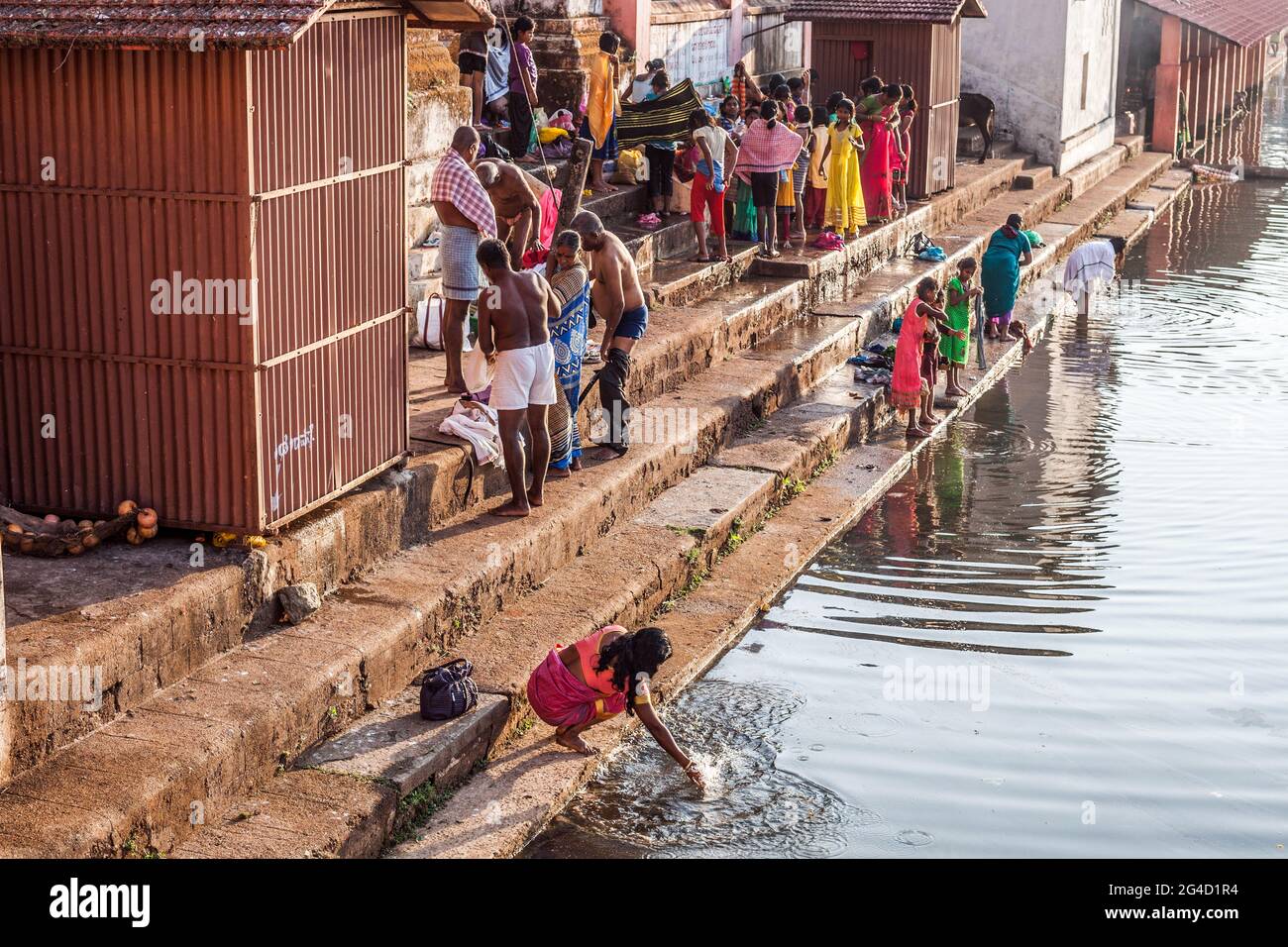 Les adorateurs indiens accomplissent leurs ablutions quotidiennes au réservoir d'eau sacré et spirituel Koti Tirtha à Gokarna, Karnataka, Inde Banque D'Images