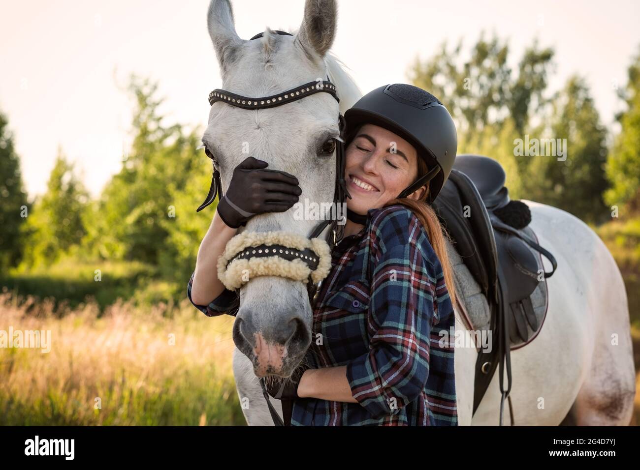 Jeune femme prendre soin de son cheval Banque D'Images