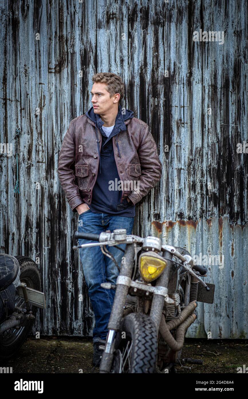 homme vêtu d'un jean et d'une veste en cuir avec moto de course de café  personnalisée Photo Stock - Alamy