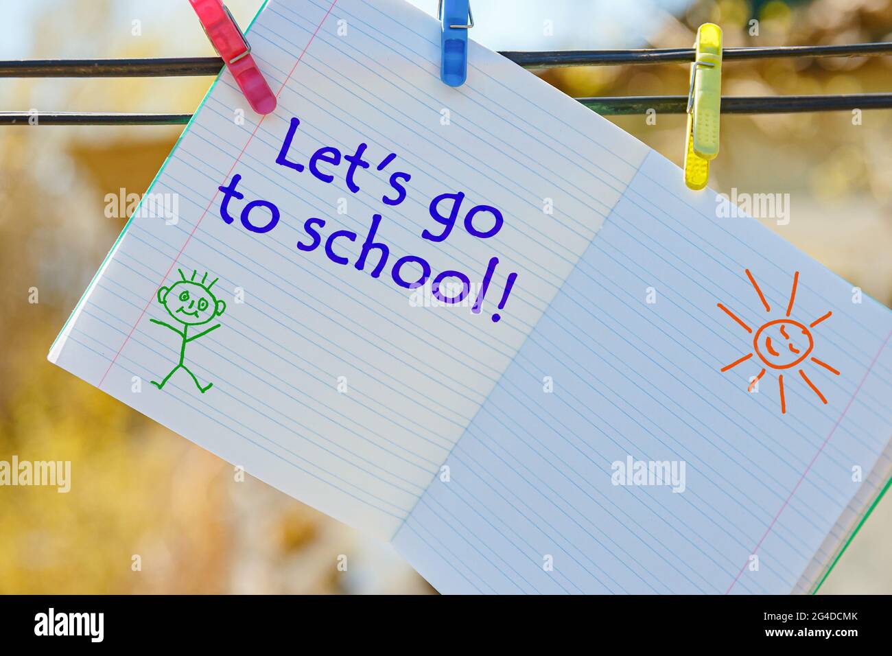 Carnet d'école avec inscription - allons à l'école, accroché à des épingles à linge. Banque D'Images