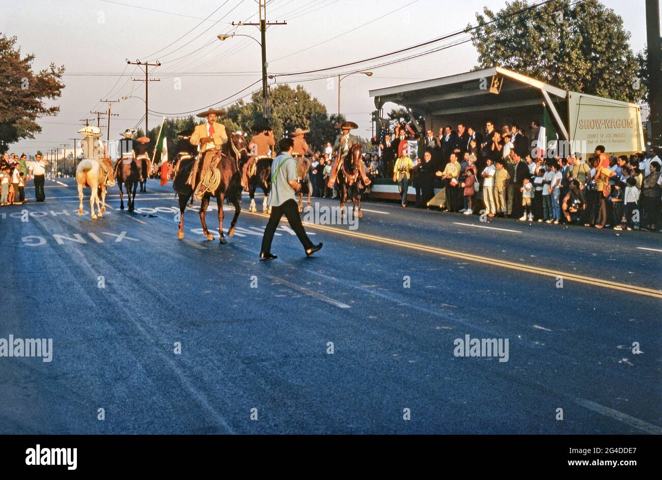 Chevaux dans une parade de la communauté Chicano à Los Angeles, Californie, Etats-Unis, 1970 (Chicanos et Chicanas sont des hommes et des femmes d'origine mexicaine). Les chevaux et l'équitation sont une partie traditionnelle de la culture mexicaine. La Journée de l'indépendance (Día de la Independencia) est un jour férié au Mexique le 16 septembre pour célébrer la libération de la domination espagnole en 1810. Les drapeaux mexicains sont visibles – détenus par l'un des cavaliers et dans la foule. Cette image est tirée d'une transparence prise par un photographe amateur – une photographie vintage des années 1970. Banque D'Images