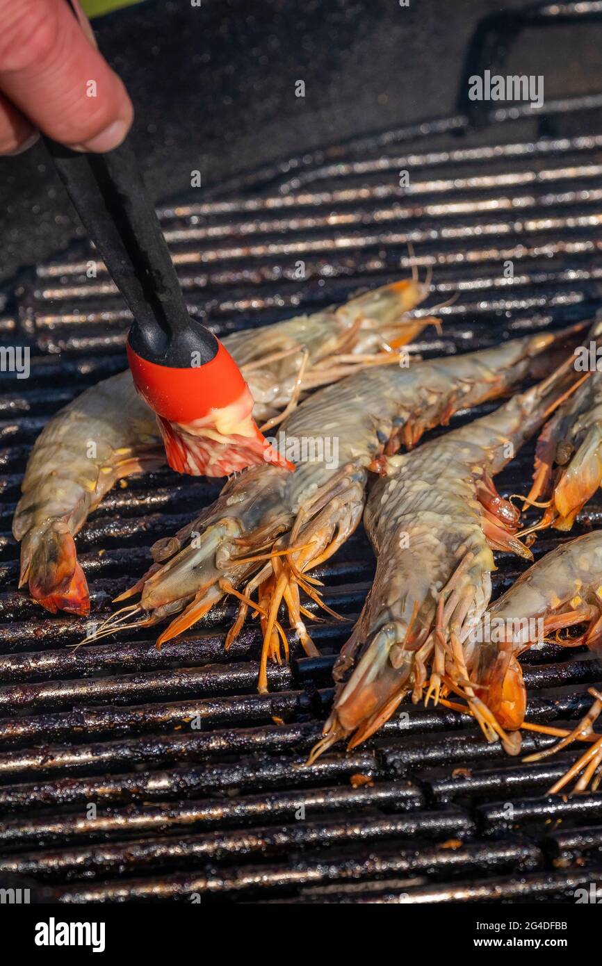 Faire cuire des crevettes sur un barbecue. Banque D'Images