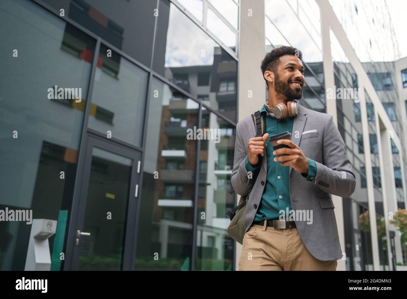 Vue de face des étudiants marchant devant le bâtiment à l'extérieur de la ville. Banque D'Images