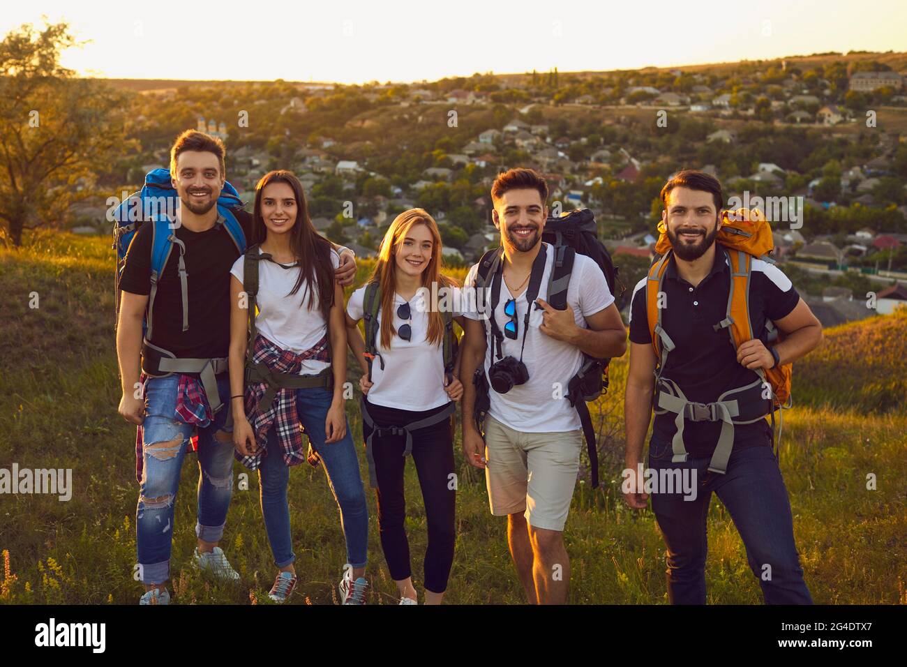 Portrait de jeunes amis avec des sacs à dos regardant l'appareil photo dans les montagnes. Une équipe de touristes qui font de la randonnée en plein air en été Banque D'Images