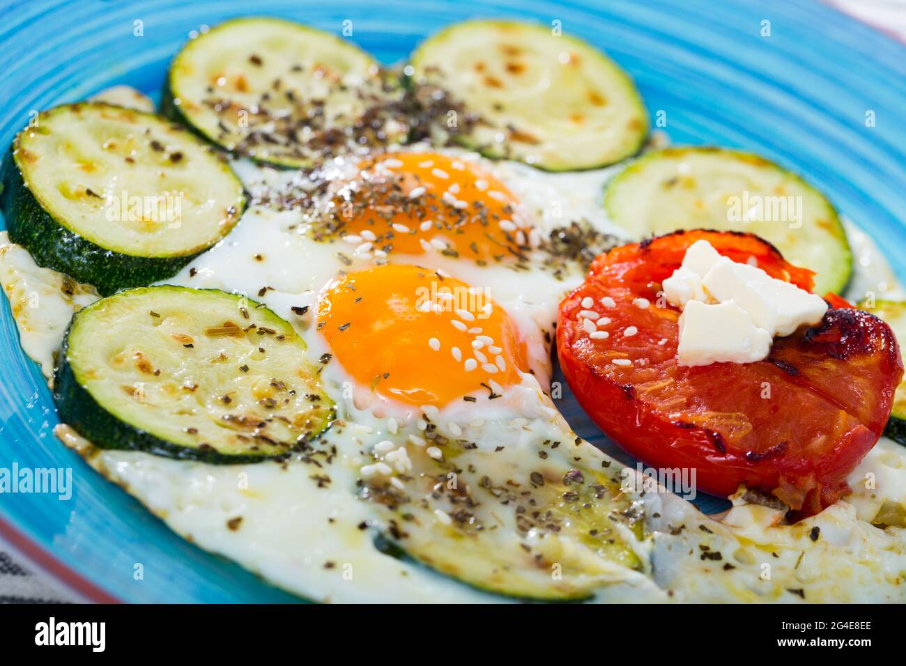 Œufs frits avec courgettes et tomates Banque D'Images