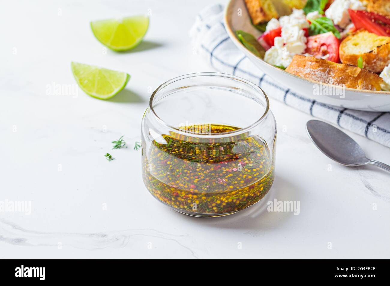 Vinaigrette à la moutarde, à l'huile d'olive et à l'aneth dans un pot en verre. Cuisine saine concept. Banque D'Images