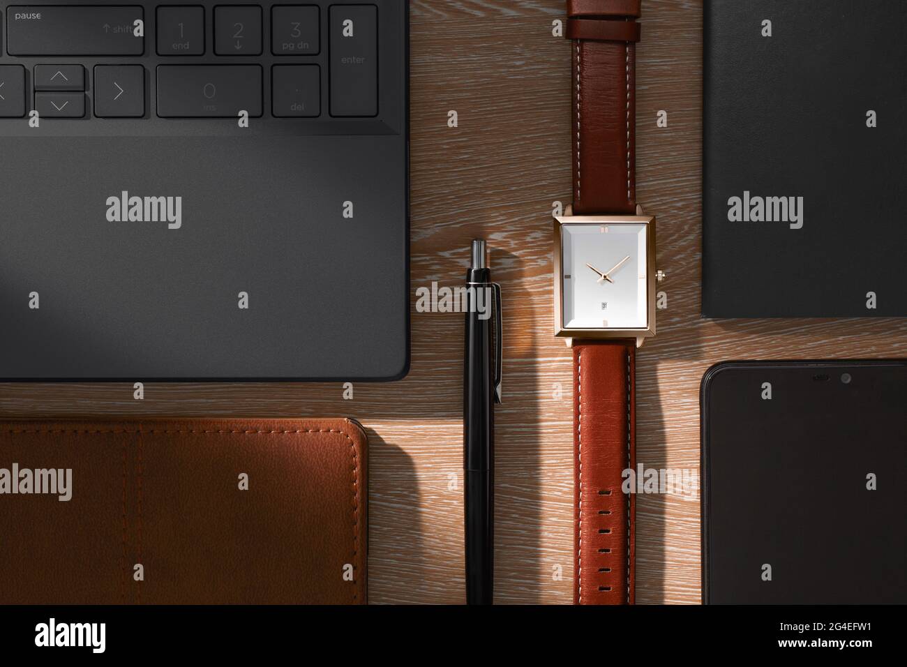 Vue depuis le dessus de la table de bureau avec ordinateur portable, ordinateur portable, stylo et montre de poignet Banque D'Images