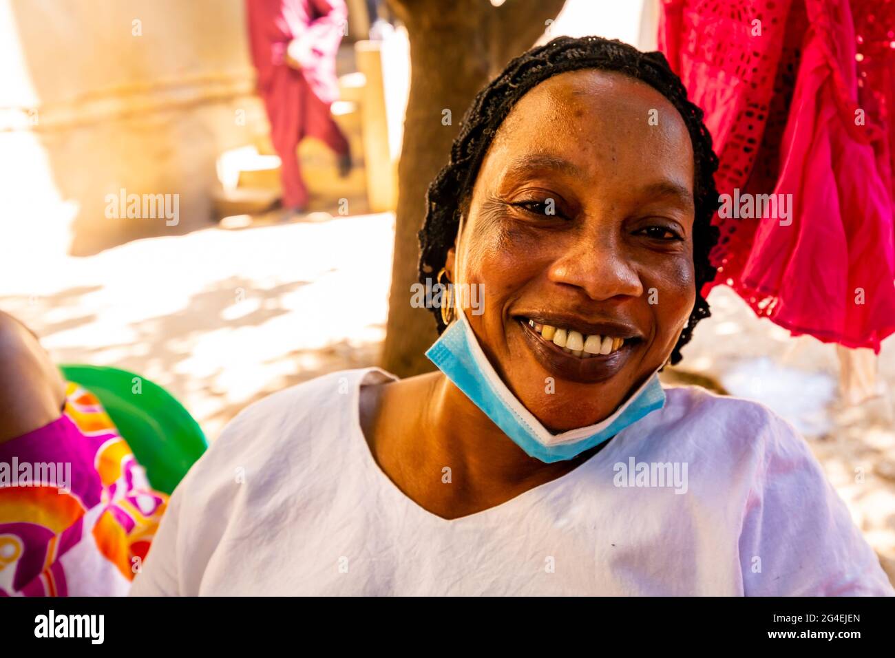 MBOUR, SÉNÉGAL - JANVIER CIRCA, 2021. sénégalaise non identifiée jolie femme mûre en robe traditionnelle en plein air regardant sourire. Pauvreté et bonheur Banque D'Images