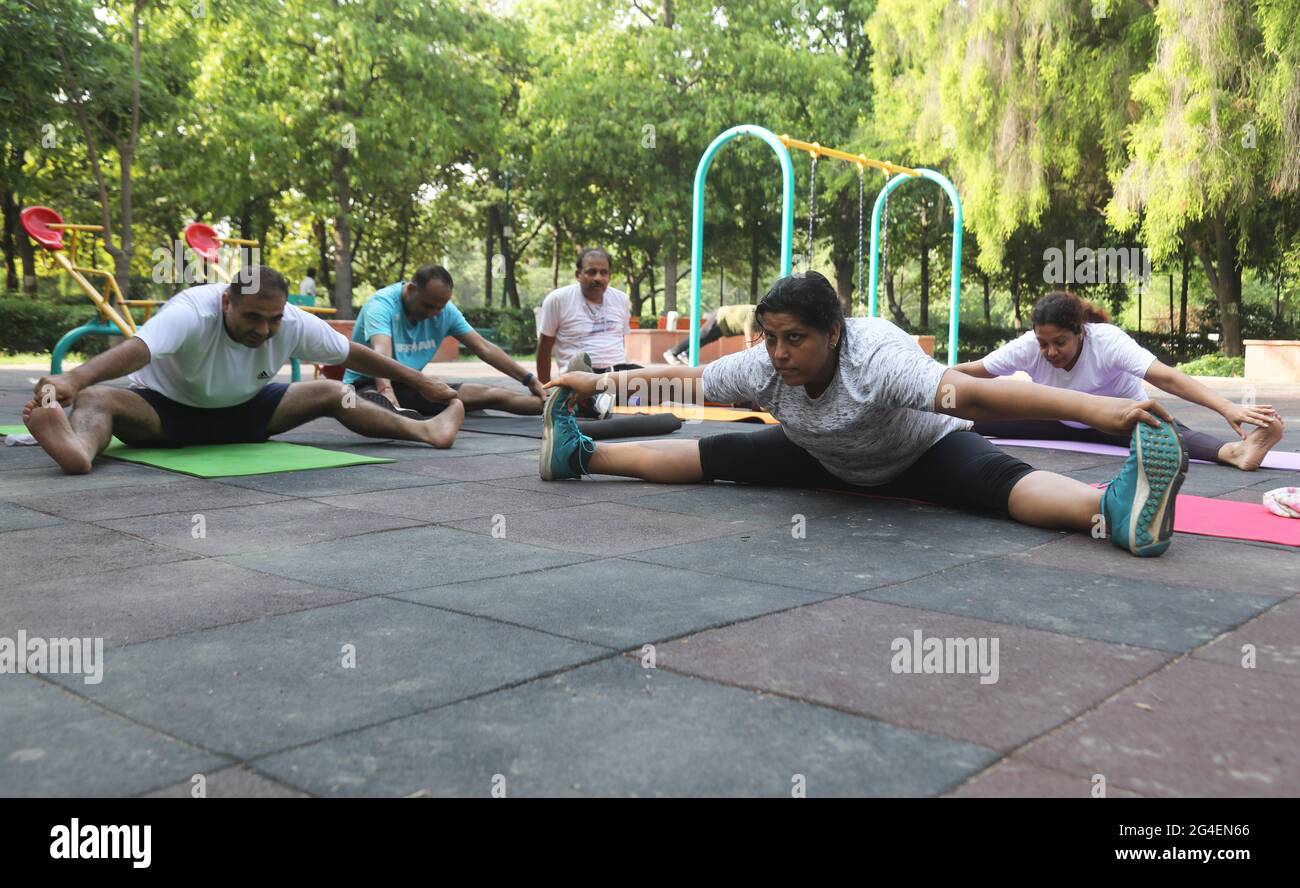 Les Indiens exécutent des postures de yoga à angle large assis en avant de  la courbe (Upavistha Konasana), pour marquer la Journée internationale de  yoga pendant la pandémie du coronavirus au District