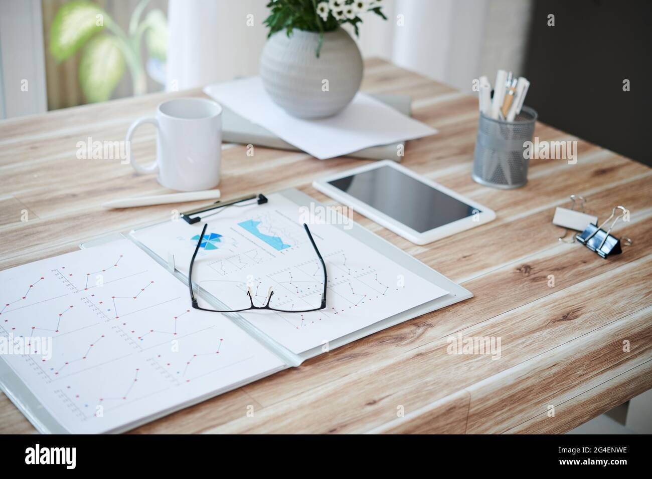 Dossier ouvert avec des rapports de ventes et des lunettes sur la table de l'entrepreneur Banque D'Images