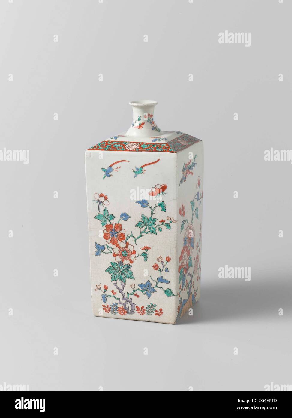 . Bouteille carrée de porcelaine avec un col court, étroit, étalant, peinte sur le glacis en bleu, rouge, vert, noir et or. Sur deux côtés, une pivoine et prunus sur une roche avec un oiseau de foin; sur les deux autres côtés, une plante en fleurs et deux oiseaux. Sur les branches de fleur d'épaule et une chrysanthème. Le cou avec deux branches de fleur. Arita, style Kakiemon. Banque D'Images