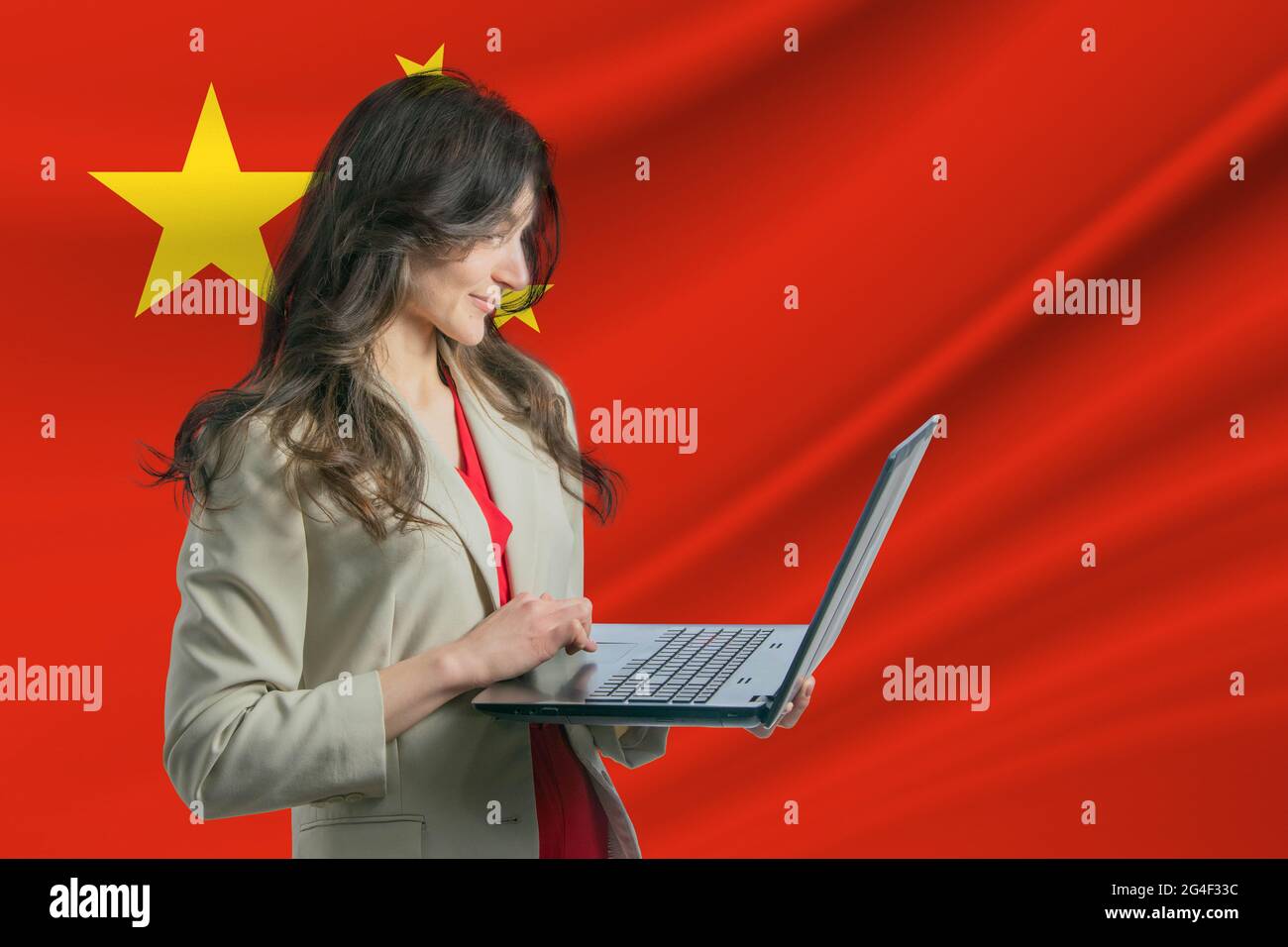 Freelance en République populaire de Chine belle jeune femme freelance utilise ordinateur portable sur le fond du drapeau Banque D'Images