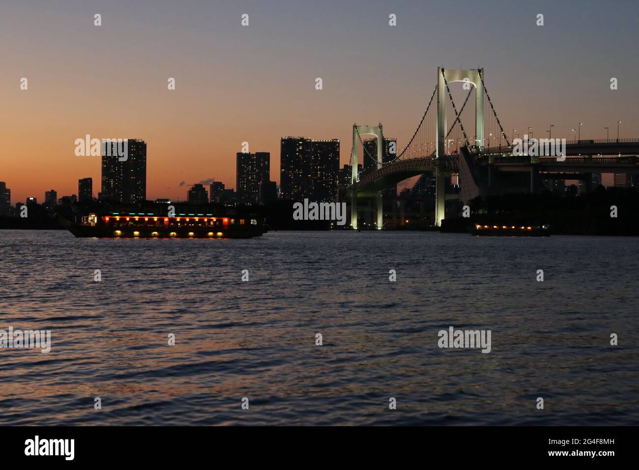 Vue depuis la plage d'Odaiba à Tokyo Bay avec Rainbow Bridge at Dusk, Tokyo, Japon Banque D'Images