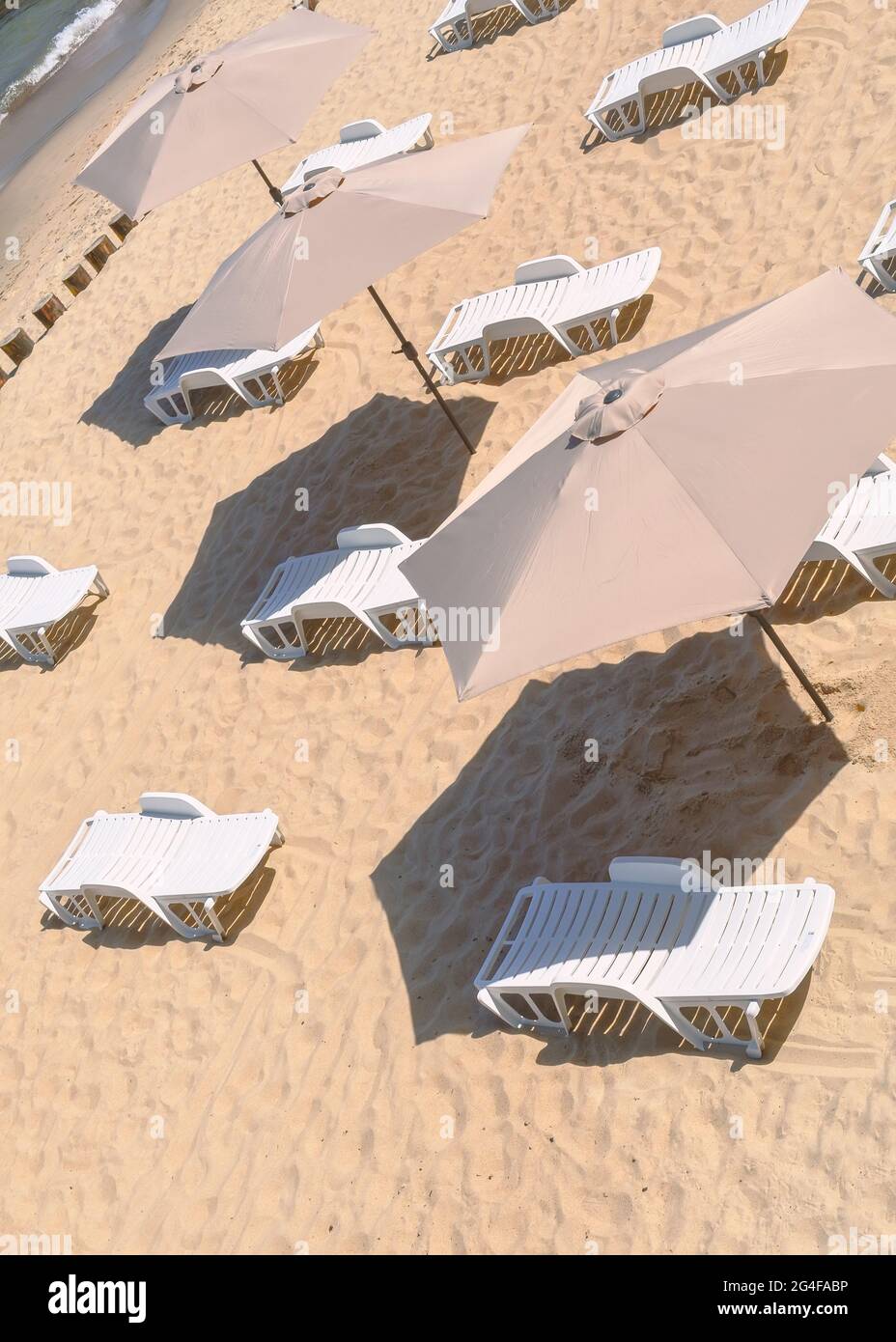 Chaises longues et parasols vides sur une plage de sable. Banque D'Images