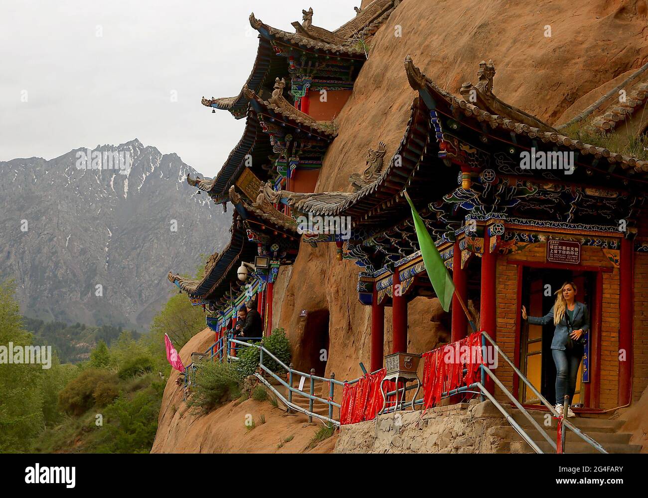 Les touristes visitent les grottes du Temple Mati près de Wangye, dans le nord-ouest de la province de Gansu, le samedi 19 juin 2021. L'ancien temple, également connu sous le nom de Temple du Hoof du cheval, est un site bouddhiste tibétain protégé avec plus de 70 grottes sculptées à la main dans la falaise. Selon la légende, Pegasus chinois a une fois atterri sur la falaise et a laissé une marque sur elle, et ainsi le temple a obtenu son nom. Le tourisme dans la province de Gansu, le septième plus grand district administratif de Chine, représente près de la moitié des revenus annuels de la province tout en restant l'une des provinces les plus pauvres du pays. Photo de Stephen Shaver/UPI Banque D'Images