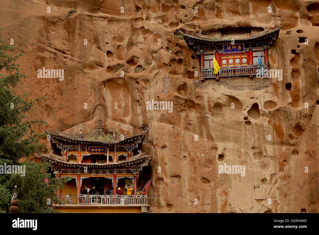 Les touristes visitent les grottes du Temple Mati près de Wangye, dans le nord-ouest de la province de Gansu, le samedi 19 juin 2021. L'ancien temple, également connu sous le nom de Temple du Hoof du cheval, est un site bouddhiste tibétain protégé avec plus de 70 grottes sculptées à la main dans la falaise. Selon la légende, Pegasus chinois a une fois atterri sur la falaise et a laissé une marque sur elle, et ainsi le temple a obtenu son nom. Le tourisme dans la province de Gansu, le septième plus grand district administratif de Chine, représente près de la moitié des revenus annuels de la province tout en restant l'une des provinces les plus pauvres du pays. Photo de Stephen Shaver/UPI Banque D'Images