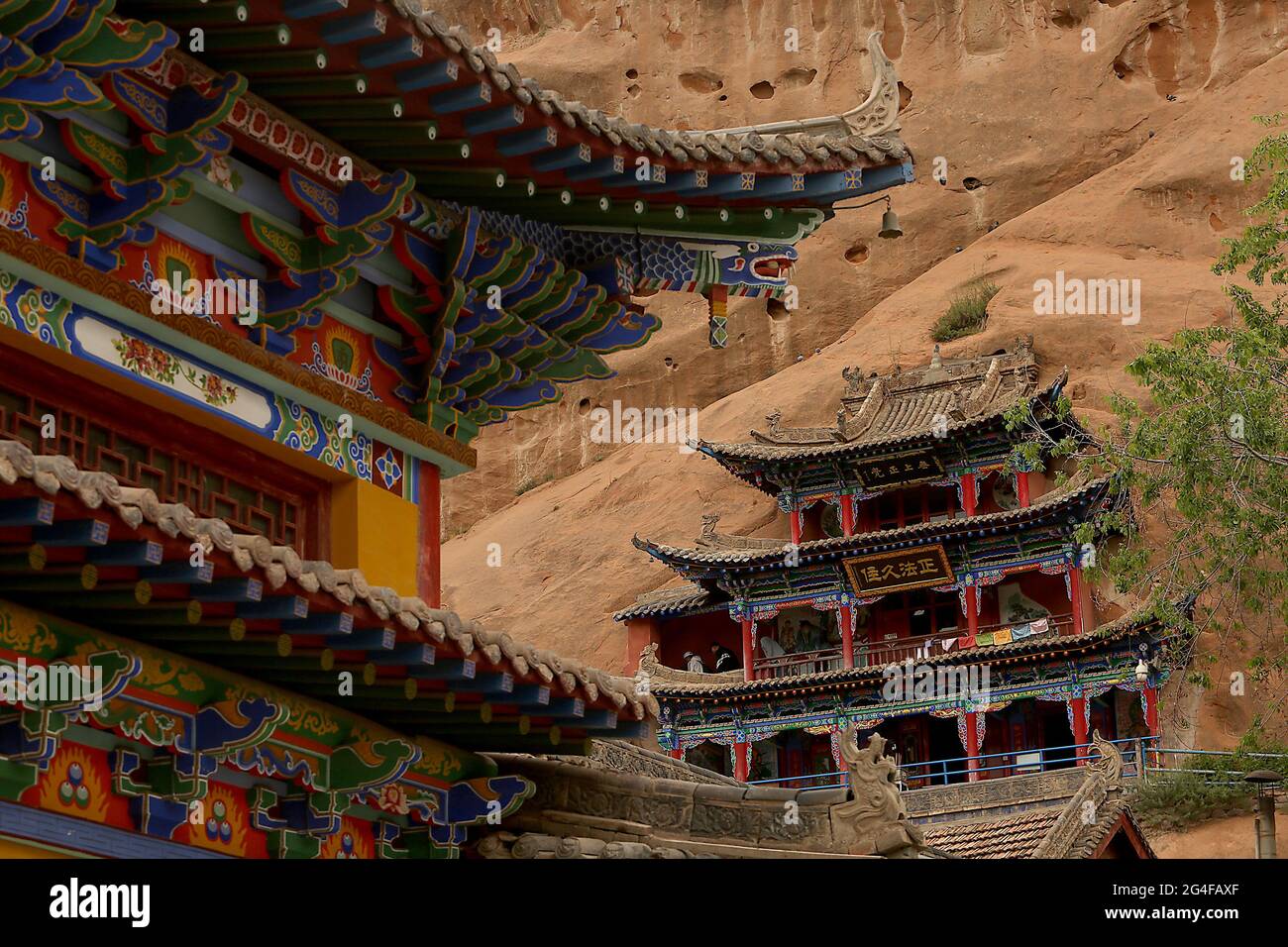 Les touristes visitent les grottes du Temple Mati près de Wangye, dans le nord-ouest de la province de Gansu, le samedi 19 juin 2021. L'ancien temple, également connu sous le nom de Temple du Hoof du cheval, est un site bouddhiste tibétain protégé avec plus de 70 grottes sculptées à la main dans la falaise. Selon la légende, Pegasus chinois a une fois atterri sur la falaise et a laissé une marque sur elle, et ainsi le temple a obtenu son nom. Le tourisme dans la province de Gansu, le septième plus grand district administratif de Chine, représente près de la moitié des revenus annuels de la province tout en restant l'une des provinces les plus pauvres du pays. Photo de Stephen Shaver/UPI Banque D'Images