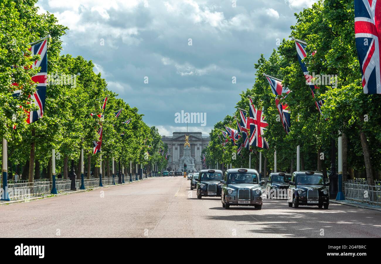 Taxis londoniens dans la rue The Mall avec des drapeaux de Grande-Bretagne alignés, à l'arrière Buckingham Palace, City of Westminster, Londres, Angleterre, Great Banque D'Images