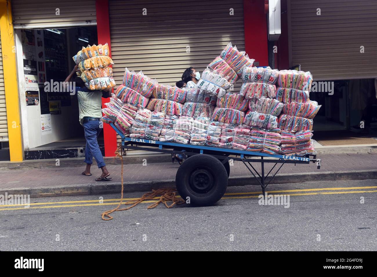 Colombo, Sri Lanka. 21 juin 2021. Un vendeur décharge des marchandises sur un marché à Colombo (Sri Lanka) le 21 juin 2021. Lundi, les autorités sri-lankaises ont temporairement levé une restriction de voyage nationale qui a été imposée en mai pour permettre le travail essentiel des personnes. Credit: Gayan Sameera/Xinhua/Alay Live News Banque D'Images