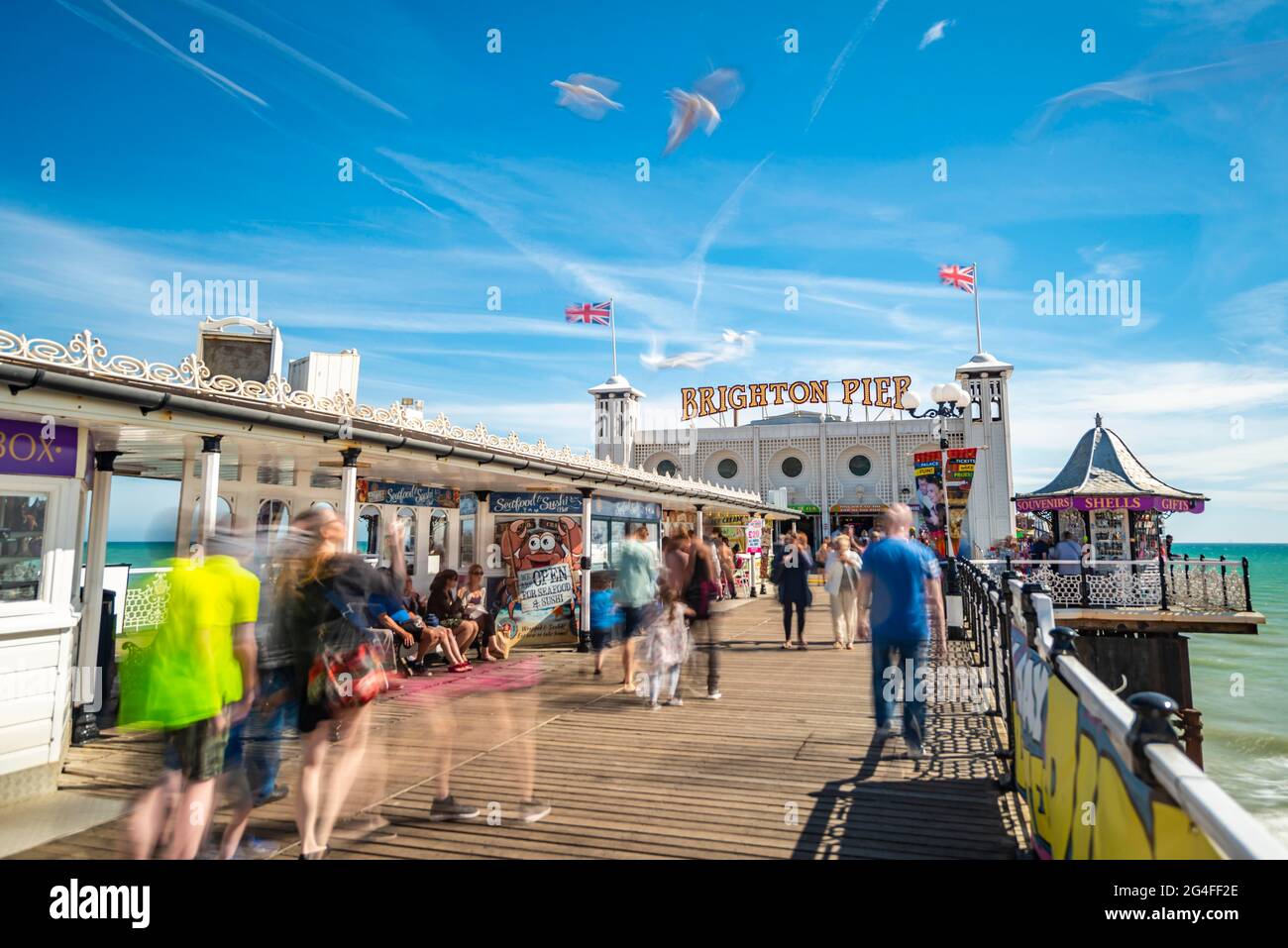 Touristes à Brighton Palace Pier avec mouettes, longue exposition, Brighton, East Sussex, Angleterre, Royaume-Uni Banque D'Images
