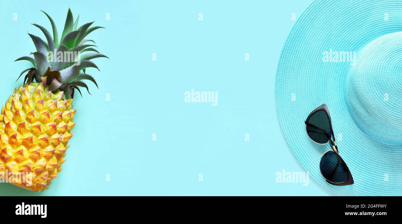 Jaune ananas et chapeau bleu avec lunettes de soleil sur fond bleu. Banque D'Images