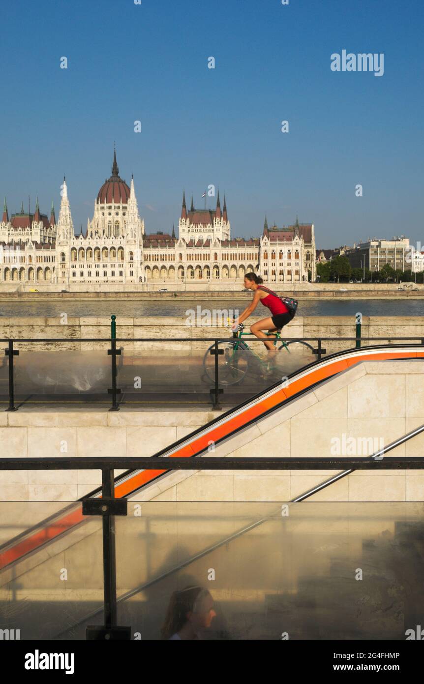 La station de métro Batthyany Ter escalier, cycliste, Danube et le Parlement national hongrois Assemby en arrière-plan, Budapest, Hongrie Banque D'Images