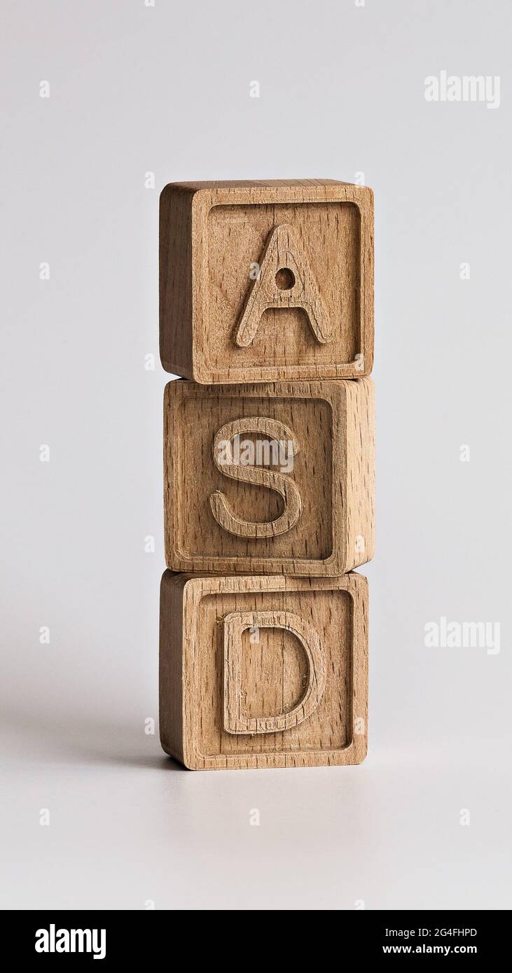Photo verticale sur le thème des TSA (troubles du spectre autistique). cubes en bois avec l'abréviation « ASD », sur fond blanc Banque D'Images