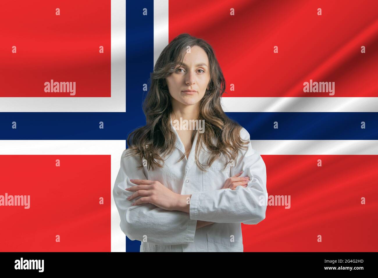 Médecine en Norvège. Bonne belle femme médecin dans un manteau médical  debout avec des bras croisés sur le fond du drapeau de la Norvège Photo  Stock - Alamy